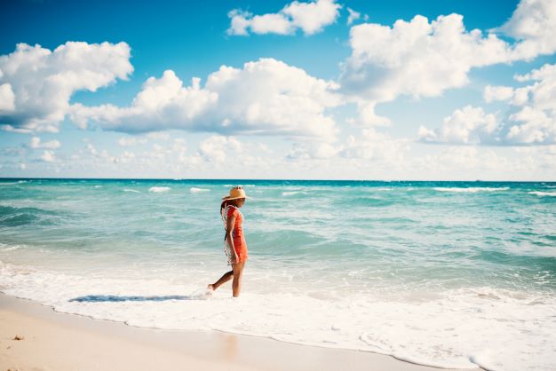 Woman of color walking along Miami Beach, Florida. 