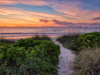 A sandy path leading to Cocoa Beach, Florida, near Orlando, at sunset