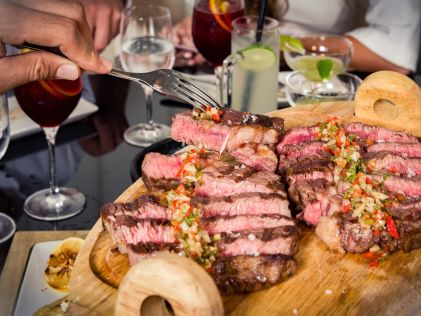 A group of people enjoying a steak dinner