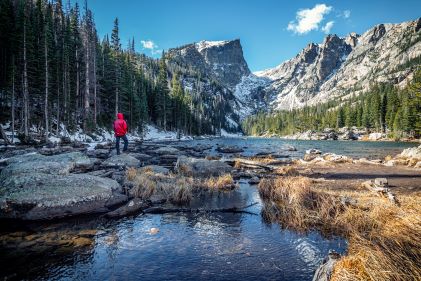 Hiker admiring  snow-capped mountains, springtime, Rocky Mountains, Colorado. 