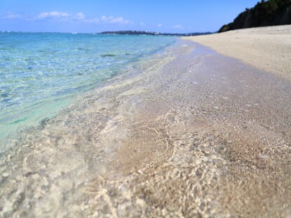 Crystal clear water washing ashore a quiet beach. 