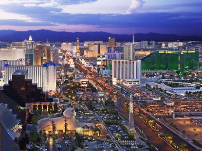 Aerial view of the Las Vegas Strip with purple painted skies overhead. 